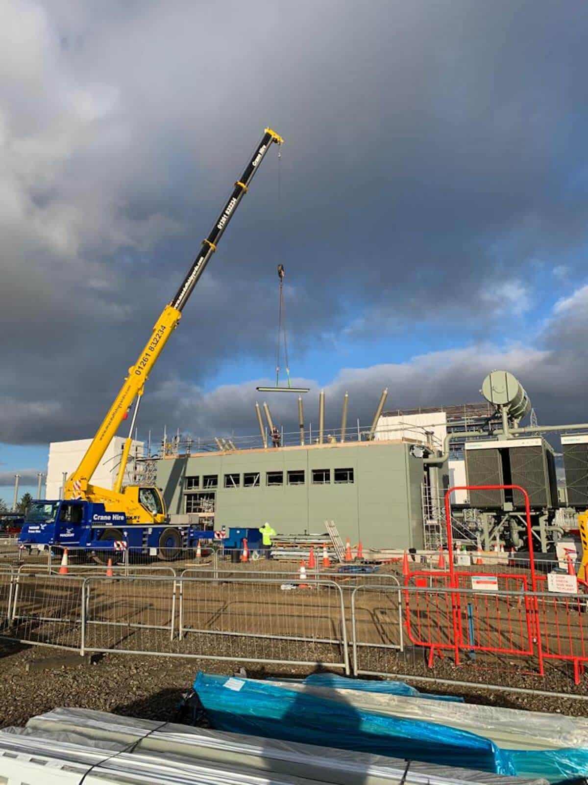 The crane lifts the roof panels into place